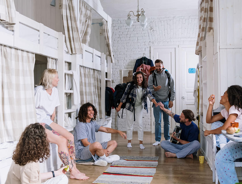 Un grupo de turistas compartiendo y conviviendo en el cuarto de un hostal.