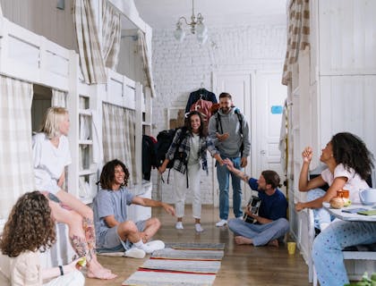 Un grupo de turistas compartiendo y conviviendo en el cuarto de un hostal.