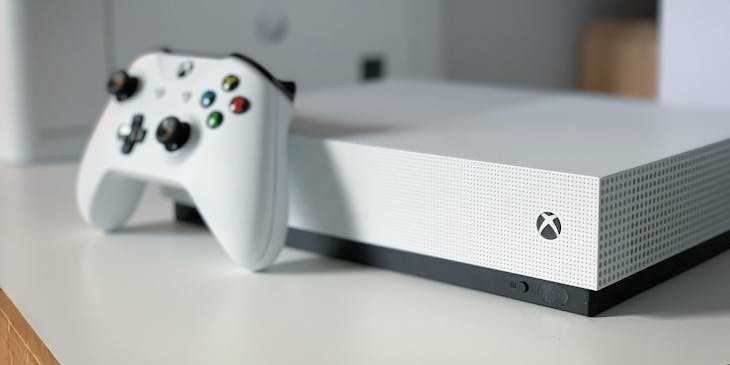 Consola y control de Xbox sobre una mesa.