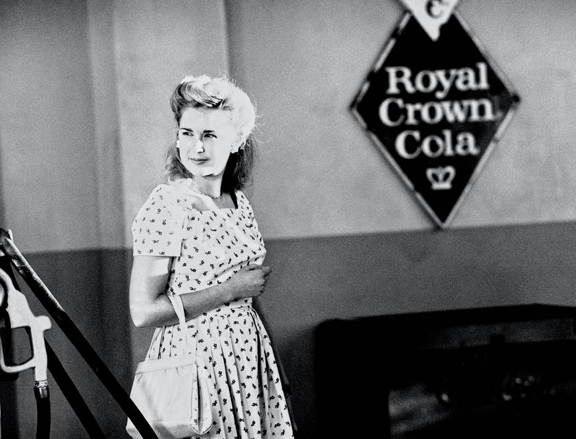 La fotografía a blanco y negro de una mujer de los años cincuenta en un negocio de arte nostálgico.