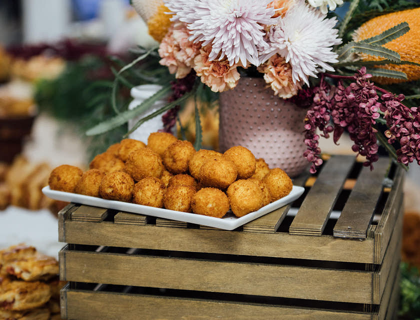 Un montón de buñuelos de bacalao sobre una bandeja de metal en un negocio de buñuelos de bacalao
