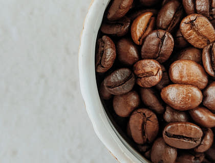Granos de café en una taza sobre un fondo blanco en un negocio de café de Galápagos.