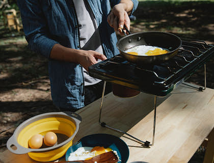 Un hombre preparando un huevo en un negocio de chorrillanas.