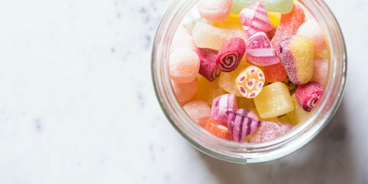 Una variedad de dulces de distintos sabores y colores dentro de un dulcero en un negocio de dulceros.