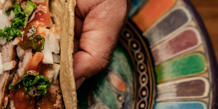 Orden de flautas sobre una cama de lechuga en un negocio de flautas.