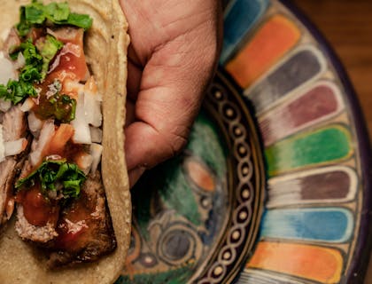 Orden de flautas sobre una cama de lechuga en un negocio de flautas.