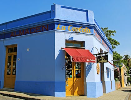 Una fonda de color azul en la esquina de una calle.