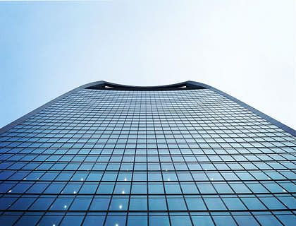 Vista desde abajo de un edifico de gestión de patrimonio con el cielo de fondo.