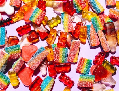 Gomitas de distintos colores y sabores sobre una superficie blanca en un negocio de gomitas.