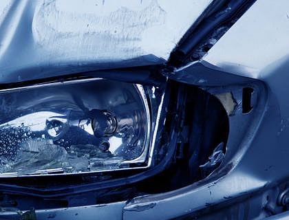 Un auto chocado en un negocio de hojalatería.