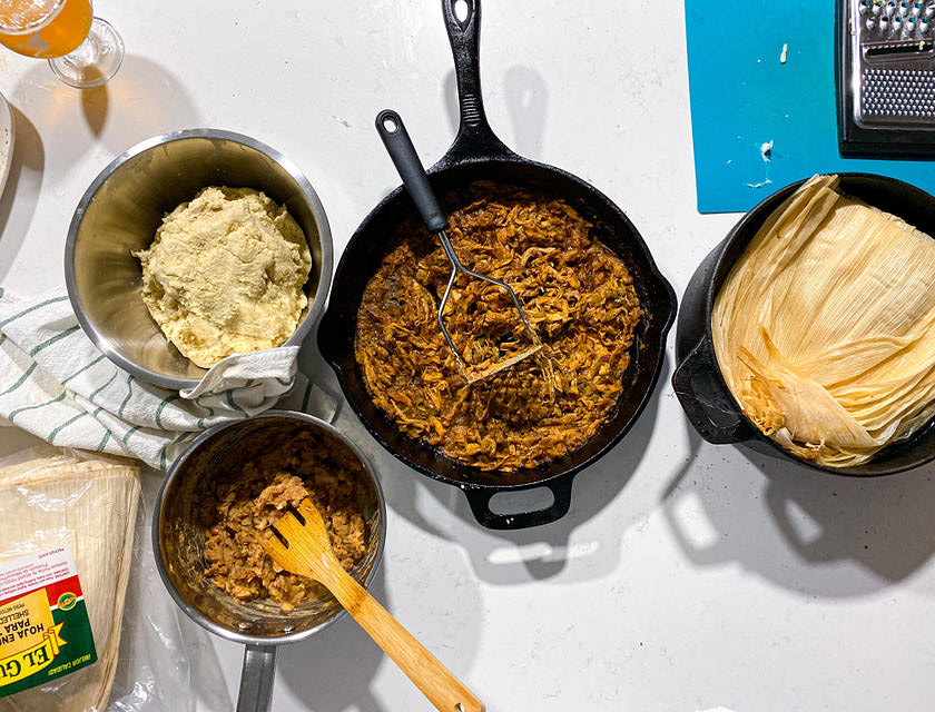 Hojas de humita, guisos y masa de maíz en ollas en un negocio de humitas listo para ser preparado.