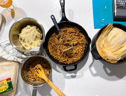 Hojas de humita, guisos y masa de maíz en ollas en un negocio de humitas listo para ser preparado.