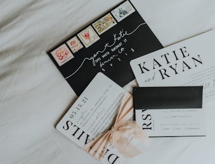 Una fotografía aérea de cuatro ejemplos de invitaciones en blanco y negro en un negocio de invitaciones.