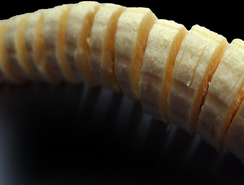 Una banana en trozos para cocinar jibaritos sobre un fondo negro en un negocio de jibaritos.
