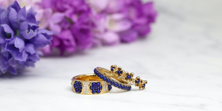 Anillos de oro con incrustaciones de diamantes y piedras preciosas de color azul en un negocio de joyas hechas a mano de Luque.
