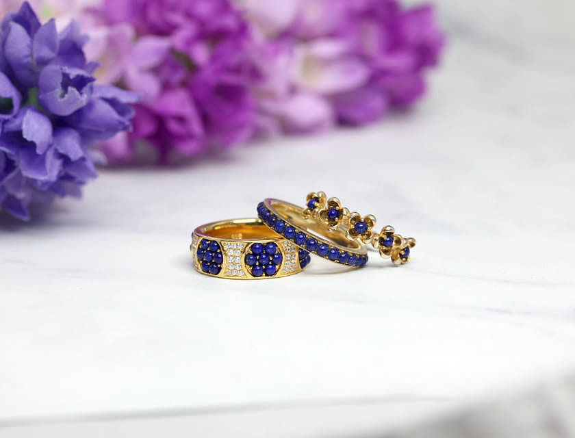 Anillos de oro con incrustaciones de diamantes y piedras preciosas de color azul en un negocio de joyas hechas a mano de Luque.
