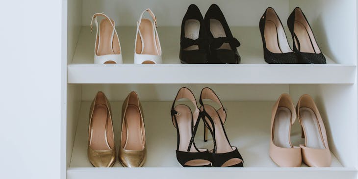 Seis pares de zapatos de mujer acomodados en un negocio de muebles zapateros