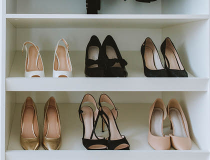 Seis pares de zapatos de mujer acomodados en un negocio de muebles zapateros