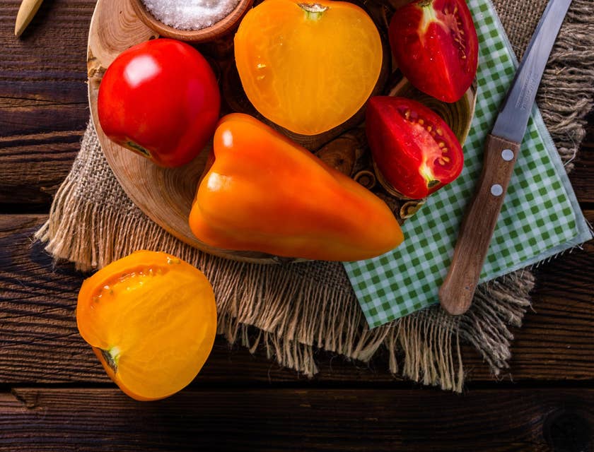 Pimentón, tomate y un cuenco con sal sobre una mesa de madera en un negocio de quiquirimichi.