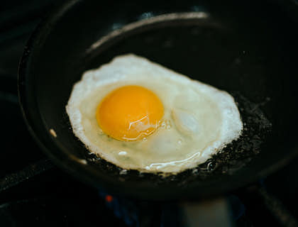 Un huevo frito sobre fondo negro en un negocio de revuelto de gramajo