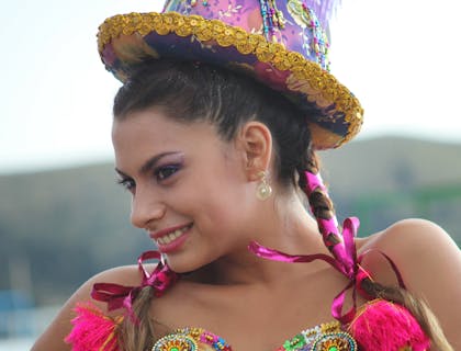 Una mujer vistiendo un sombrero de chola en una celebración boliviana.