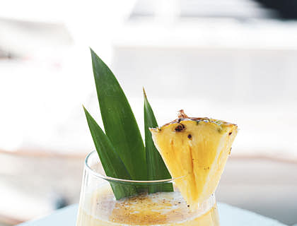 Un vaso de tepache decorado con un trozo de piña en un negocio de tepache.