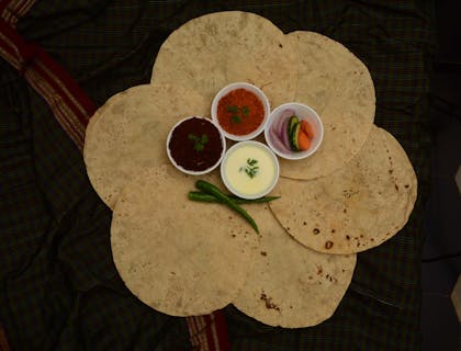 Seis tortillas extendidas con aderezos al centro listas para utilizarse en un negocio de tlayudas.