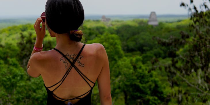 Mujer con un tatuaje en la espalda observando la selva maya en un negocio de tours a mMyan Eden.