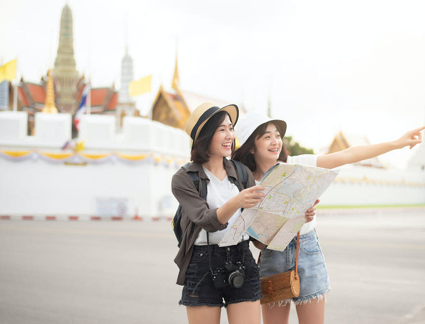Dos mujeres sosteniendo un mapa en un negocio de turismo.