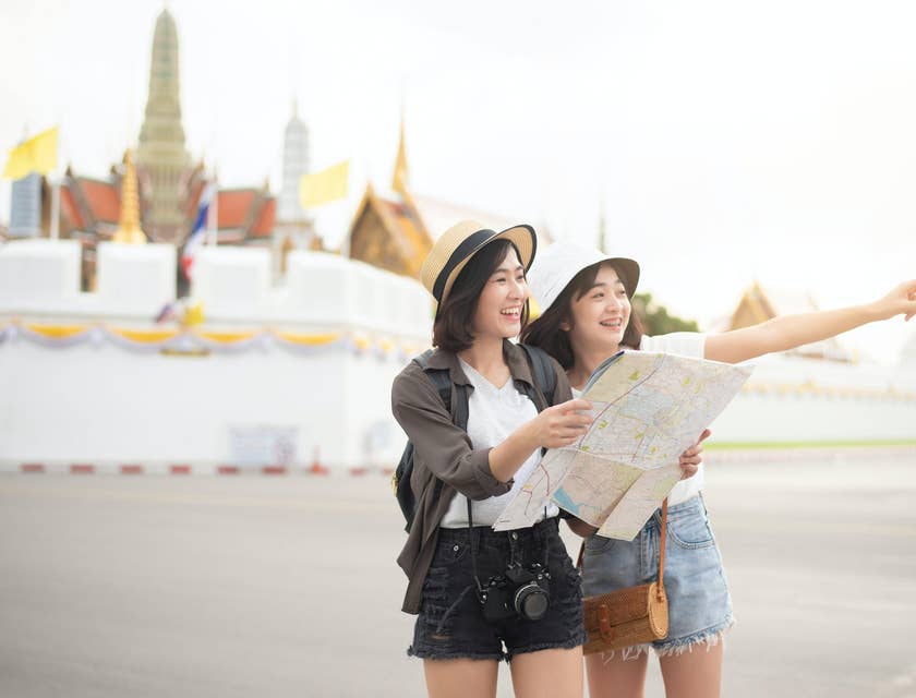 Dos mujeres sosteniendo un mapa en un negocio de turismo.