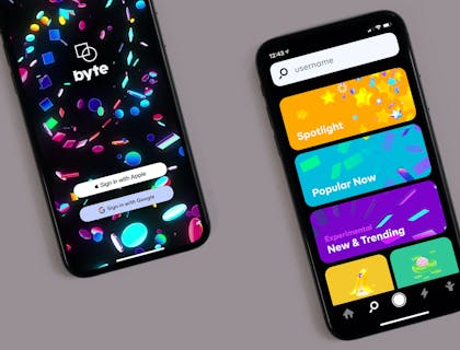 Dos teléfonos celulares con la pantalla encendida sobre un fondo gris en un negocio de venta de celulares.