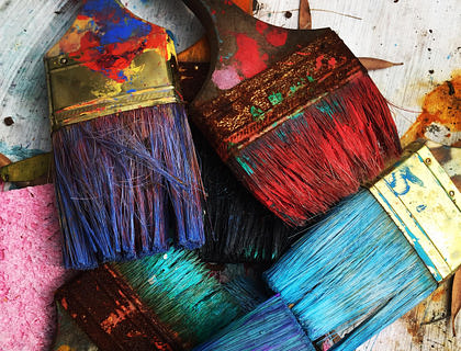 Una fotografía de varias brochas en diferentes colores en una página de arte.