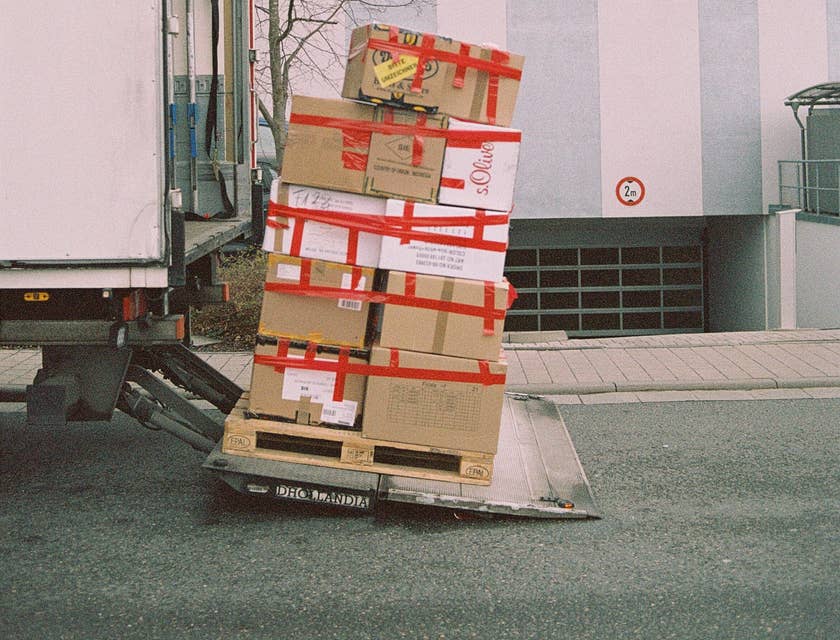 Cajas de cartón apiladas una sobre otra a punto de ser subidas a un camión de paquetería.