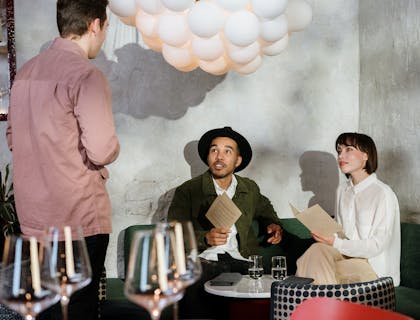 Una pareja ordenando sus platillos al mesero de un restaurante boliviano.