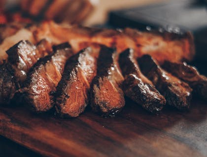Un corte de carne con corteza e interior jugoso y rosado en un restaurante de churrascos.
