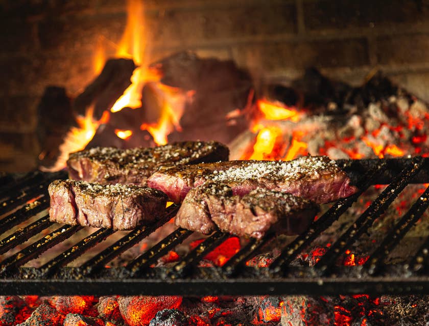 Carnes a las brasas en una parrilla de carbón en un restaurante de comida texana.