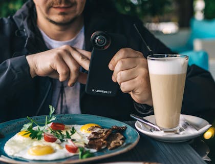 Un comensal tomando una foto con su celular a su platillo en un restaurante ecuatoriano