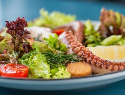 Un plato con mariscos, pescado y ensalada en un restaurante pescetariano.
