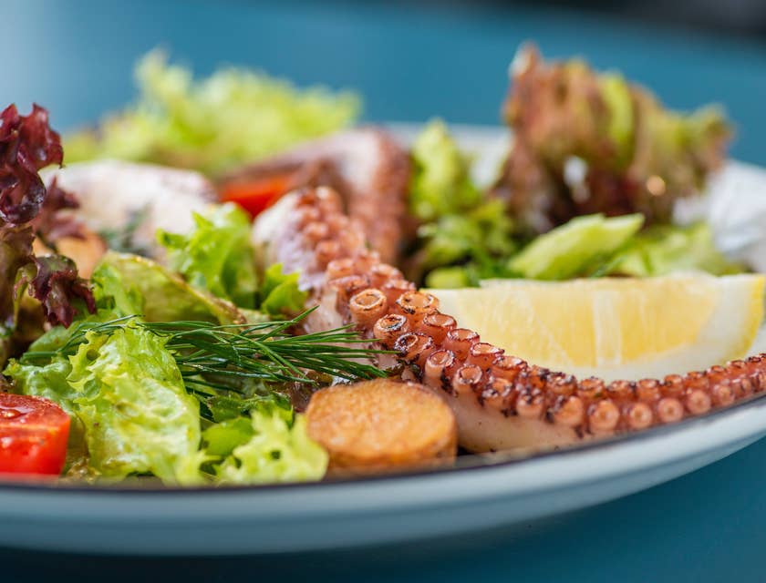 Un plato con mariscos, pescado y ensalada en un restaurante pescetariano.