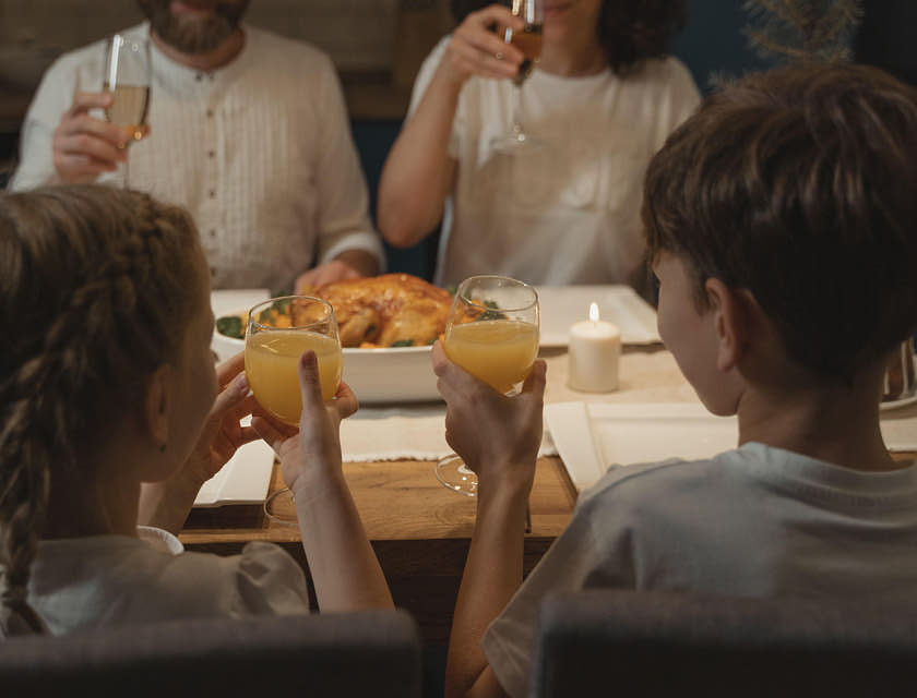 Una familia brindando y comiendo en un restaurante rumano.