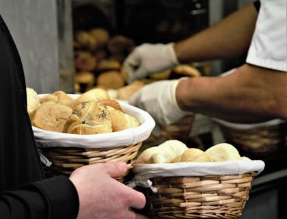 Un cliente sosteniendo dos canastas de pan en una tahona.