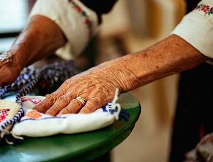 Manos de anciana Kuna sobre unas molas en un taller de confección de molas.