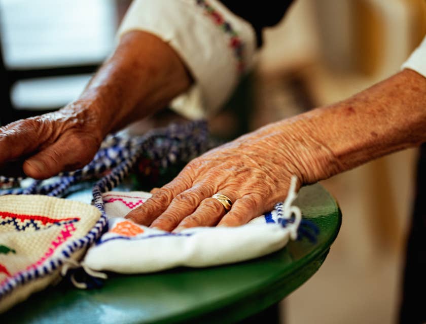 Manos de anciana Kuna sobre unas molas en un taller de confección de molas.