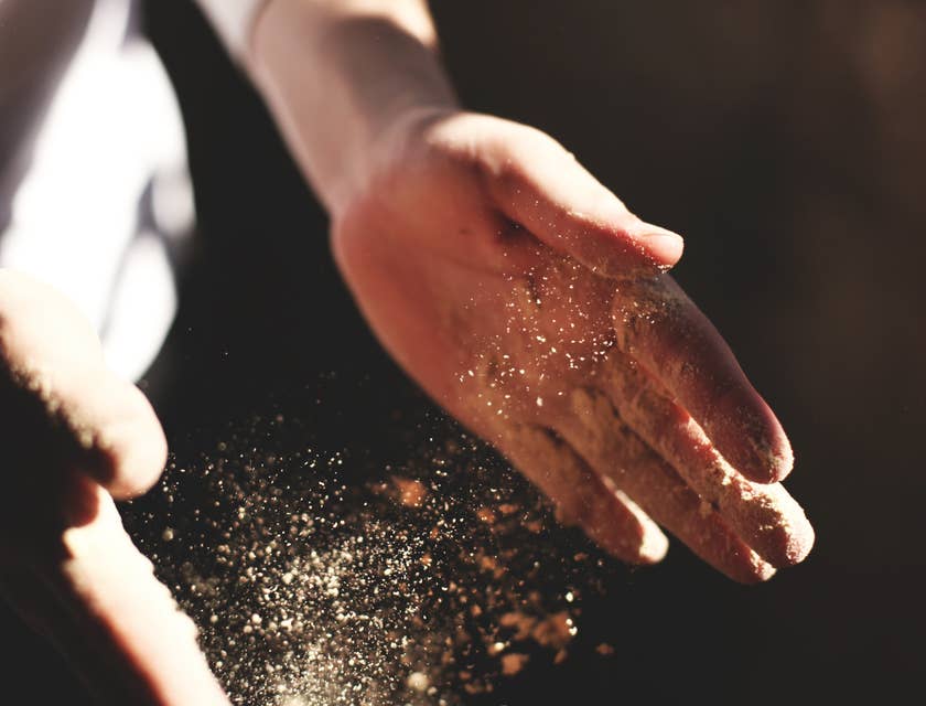 Manos de hombre esparciendo harina para preparar un chumbeque en una tienda de chumbeques.