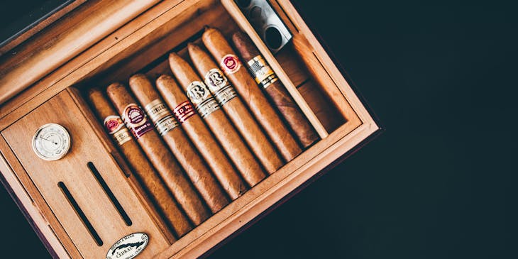 Habanos guardados dentro de un humidor sobre una superficie oscura en una tienda de humidores.