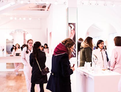 El interior de una tienda de maquillaje muy femenina por sus tonos rosas.