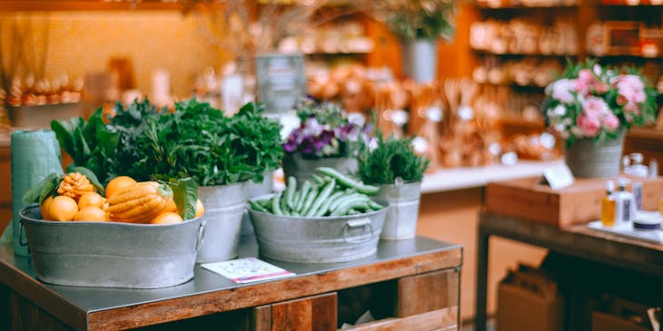 Frutas, vegetales, plantas y flores en una tienda de productos naturales.