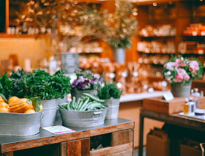 Frutas, vegetales, plantas y flores en una tienda de productos naturales.