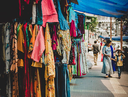 Distintas prendas colgadas en una tienda de ropa de paca.