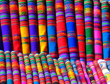 Telas de colores acomodadas y dobladas en una tienda de textiles típicos de Guatemala